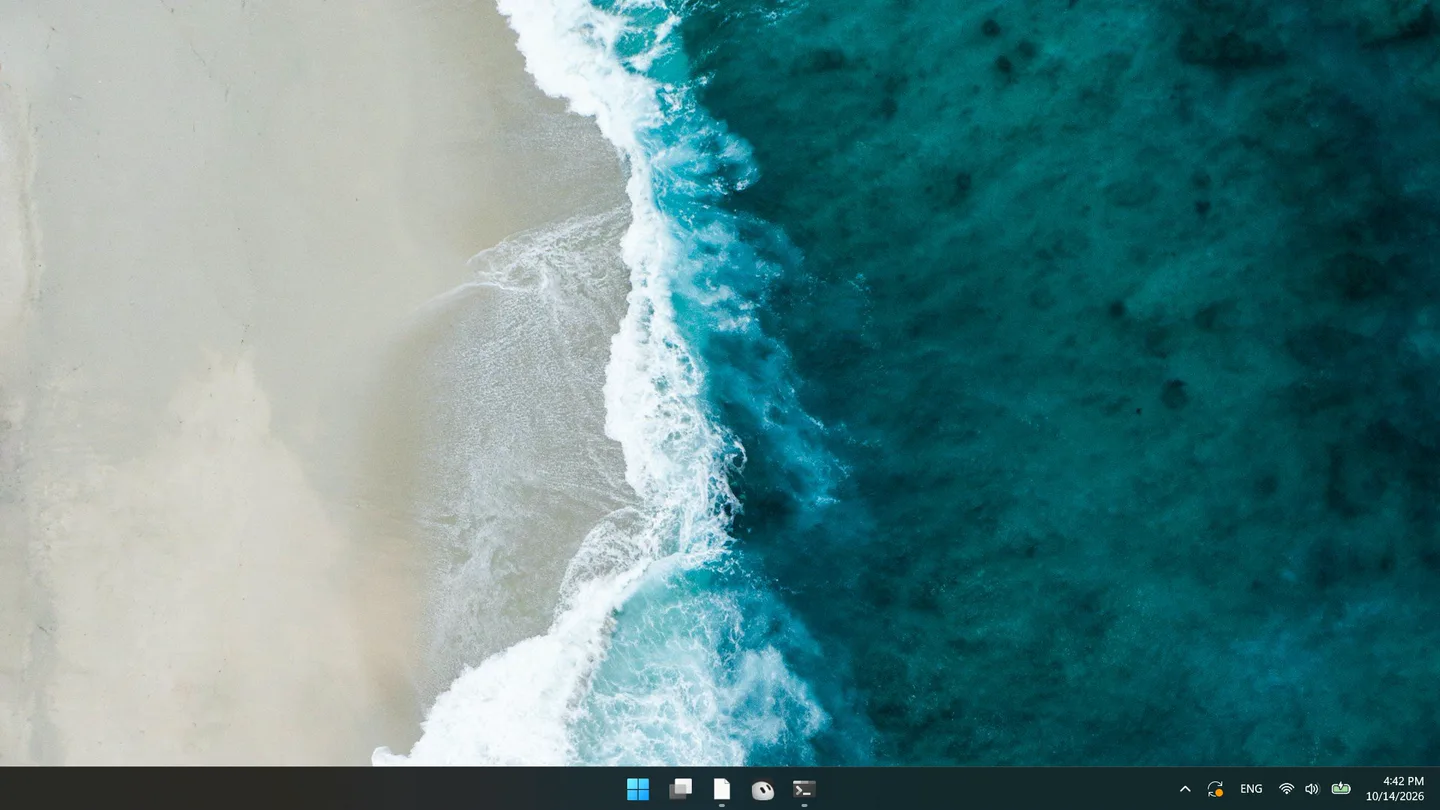 A Windows 11 desktop with an aerial beach wallpaper and the standard taskbar along the bottom